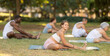 © JackF - Multinational people of different ages in park practicing yoga. Amateurs performing gymnastic. Woman yoga master and followers do Janu Shirshasana. People practice sports during in nature