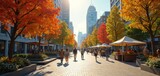 People walk along a bright city plaza lined with colorful autumn trees and market stalls. Tall modern buildings rise behind the vibrant urban scene. Shoppers browse outdoor vendor displays.