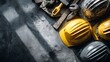 © sungedi - Assortment of safety headwear and tools rests on a textured surface with dramatic lighting