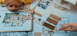 © InfiniteFlow - Hands examining color samples and floor plans, showcasing the collaborative and creative process of interior design and home renovation planning for artistic projects. SACTR