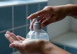 © Meow Creations - Hands pressing pump bottle to dispense hand sanitizer for personal hygiene