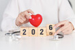 © Jo Panuwat D - 2025 end year to Happy New Year 2026 with Stethoscope of doctor and heart shape on table. health care, Insurance, Wellness and medical concepts