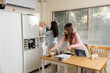 © sorapop - Young business people busy working, office financial team consults, organizing important documents, woman puts box on shelf, other woman works with tablet and paperwork at desk