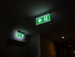 © tete_escape - Green illuminated emergency exit signs in a dark hallway indicate escape routes for building safety. Useful for themes of evacuation, hotel security, fire safety, and emergency preparedness.