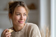 © Jane_S - Young caucasian female enjoying pastry at home with a joyful expression