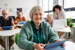 © Halfpoint - Older woman learning digital skills during course at community center.