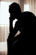 © astrosystem - Silhouette of depressed, sad and lonely man in the apartment.