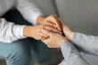 © Prostock-studio - A psychotherapist holds the hands of a young woman in a closeup view during a therapy session. The gesture symbolizes connection and emotional support in a safe environment for healing.