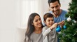 © ArtMajestic - Family decorating Christmas tree with blue ornaments, smiling happily together in home. Family bonding and holiday celebration banner with copy space
