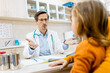 © Zoran Zeremski - Male pediatrician consulting with a woman and her young child during a medical checkup in clinic.