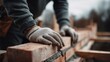© Di Studio - clsoe up of builder's hands in gloves building a brick wall