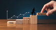 © Pixel Studio - Business growth concept showing a graph climbing upwards from crisis to management with a silhouette of a businessman climbing wooden blocks representing success and strategic planning