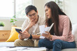 © KMPZZZ - Stressed financial owe asian young couple love sitting suffer, stressed and confused by calculate expense from credit card bill, no money to pay, mortgage or loan. Debt, bankrupt or bankruptcy people.