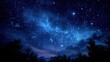 © mila103 - A clear night sky filled with bright stars illuminates the landscape. Trees silhouette against the glowing blue starlight creating a peaceful atmosphere during twilight.