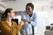 © fizkes - Two happy diverse young female colleagues making fist bump gesture