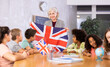 © JackF - High school teacher holds the national flag of Great Britain in her hands and tells the pupils the history of the country