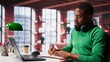 © DC Studio - Smiling black man taking notes while watching a tutorial presentation, doing online self learning and writing details. Young adult freelancer writes in his textbook notepad. Camera A.
