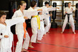 © JackF - Group of teenage children of different ages for training. Boys and girls in kimono do karate in the hall.