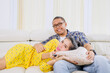 © Creativa Images - Happy Couple Relaxing on Sofa Together, Woman Lying on Man's Lap Watching TV