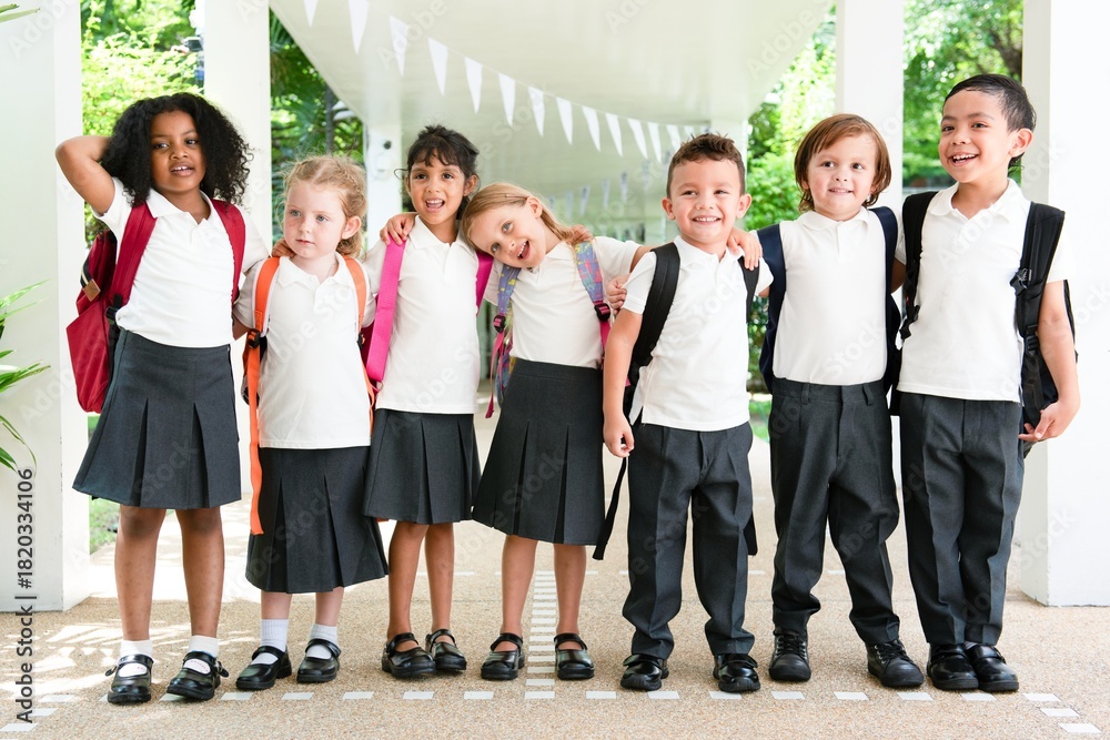 Group of diverse children in school uniforms with backpacks, smiling ...