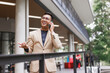 © crizzystudio - Asian businessman smiling talking on mobile phone outdoors