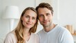 © thanawat - A couple shares a warm smile, showcasing intimacy and connection in a cozy indoor setting.