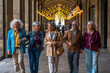 © unai - Senior friends enjoying urban travel walking under colonnade lights