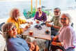 © unai - Senior friends enjoying coffee cups at outdoor cafe