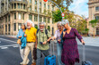 © unai - Senior friends traveling together crossing city street with luggage