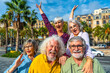 © unai - Cheerful senior friends enjoying group travel in city