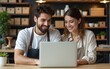 © Isabella - Two young shop owners using a laptop in their store. High quality