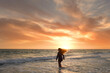 © Cavan Images - Behind teenage girl flipping hair on beach beautiful sunset Gulf