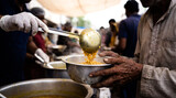 Volunteer serving hot curry rice food into metal bowl held by poor person hands charity donation india humanitarian aid hunger poverty community kitchen meal religion kindness social work relief