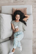 © kite_rin - Young woman relaxing at home using smartphone. African american girl texting on mobile phone resting in her room. Enjoy life, relaxation, wellbeing, holiday lifestyle, people