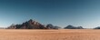 © TommyNa - Wide desert landscape with rocky mountains under a clear blue sky, showing warm tones and open space in a dry natural environment, idea for travel themes, nature visuals, and background scenes