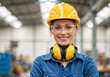 © Vasiliy - Portrait of a smiling female industrial worker wearing a yellow hard hat and safety goggles in a factory. Happy woman engineer with ear defenders. Industrial safety concept