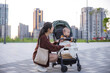 © leungchopan - Woman take baby for walk with stroller