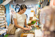 © leungchopan - Woman shopping and looking at gifts in store