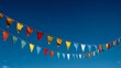 © Yuliia - Colorful triangular bunting flags hanging against deep blue sky, creating festive atmosphere for outdoor celebrations and events.