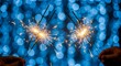 © Mahdi - Sparkling celebration with two handheld sparklers against a backdrop of soft blue bokeh lights