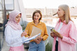 © Maria Vitkovska - Diverse group of multinational businesswomen holding clipboard talking, planning project outdoors