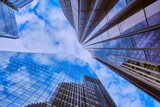 Wide-angle view of skyscrapers in the City of London against a blue sky with light cloud.