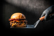 © changju.kang - Gourmet Double Smash Burger with Crispy Bacon and Melted Cheese on a Spatula