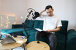 © YuliaSmyt - Asian man reviewing notes while recording audio at home, sitting by a microphone in a casual home studio. Focused remote-work or podcast preparation moment