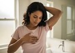 © AlfaSmart - Woman practicing self breast examination in home bathroom setting for health awareness