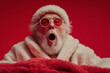 © KETE - Santa in yawning pose under red background wrapped in red blanket for cute Christmas stock photo