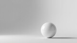 A Single, Smooth, White Sphere Rests on a Pristine, Light Gray Surface, Illuminated by Subtle, Soft Lighting