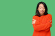 © Pixel-Shot - Young Asian woman hugging herself on green background