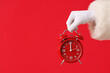© Pixel-Shot - Santa Claus holding alarm clock on red background, closeup