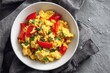 © Iftikhar alam - Delicious tofu scramble topped with fresh red bell peppers and green onions in a cozy kitchen setting